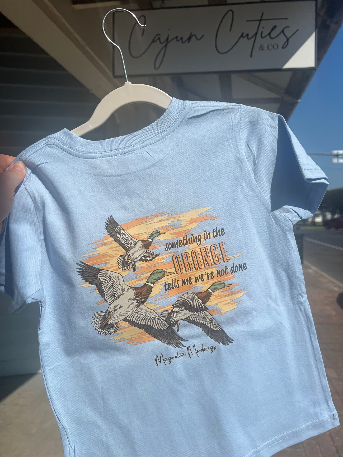 Child's vibrant baby blue t-shirt featuring a fun orange duck design on the back, perfect for young adventurers.