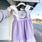 Child’s Mardi Gras dress in Swiss dot pattern, featuring traditional carnival colors of purple, green, and gold