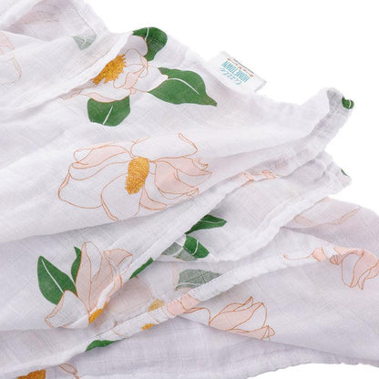 Close-up of the Little Hometown Southern Magnolia bamboo swaddle blanket showing the lightweight muslin texture and elegant magnolia floral print.