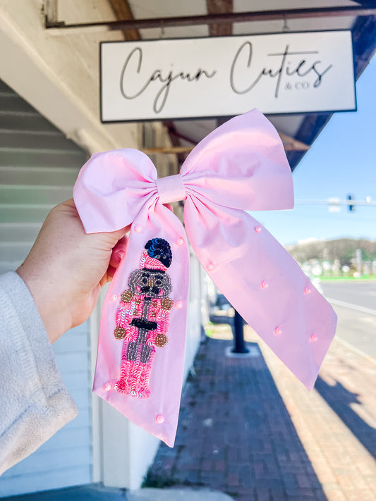 Handcrafted Nutcracker-themed hair bow adorned with sequins and pearls, perfect for holiday celebrations and ballet events