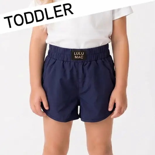 Toddler girl wearing Lulu Mac navy boutique shorts with an elastic waistband 